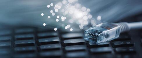 The Ethernet cable connecting to a keyboard with abstract light effects. photo