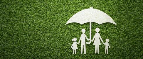 The family under an umbrella symbolizing protection and togetherness on grass. photo