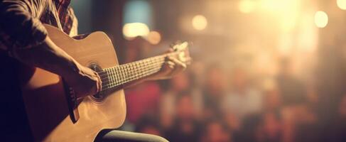 The musician passionately playing an acoustic guitar on stage during a vibrant performance. photo