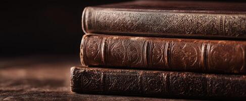 The aged leather-bound books resting elegantly on a wooden surface. photo