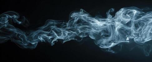 The delicate wisps of smoke dancing against a black background photo