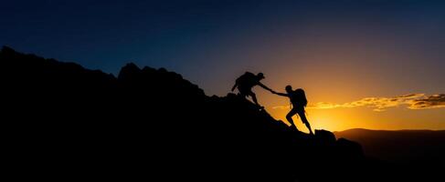 The climbers helping each other reach the summit during a breathtaking sunset. photo