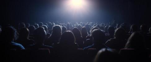 The audience captivated by a cinematic experience in a darkened theater setting. photo