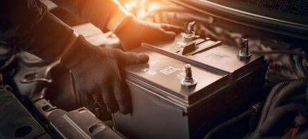 The technician installing a high-performance battery in a vehicle engine. photo