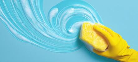 The vibrant sponge creating a soapy swirl on a blue background. photo