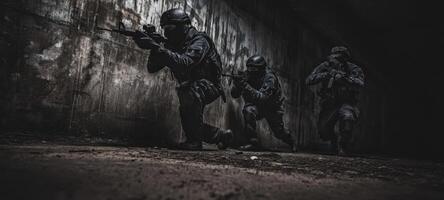The soldiers executing a tactical maneuver in a dimly lit environment. photo