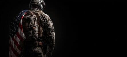 The soldier proudly wearing the American flag in a dark, moody setting. photo