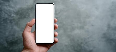The close-up of a blank smartphone held in a hand against a textured background. photo