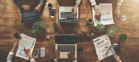 The collaborative workspace showcasing teamwork around modern laptops and documents. photo