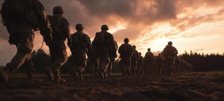 The soldiers marching confidently into the sunset during training deployment. photo
