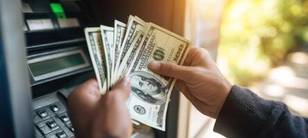 The person holding cash from an ATM while enjoying outdoor sunlight. photo