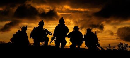 The silhouettes of soldiers against a dramatic sunset sky during military training. photo