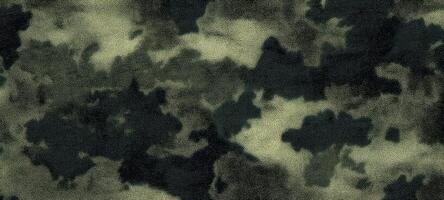 The textured camouflage pattern featuring shades of green and black. photo
