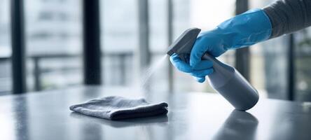 The hand using a spray bottle to clean a cloth on a surface. photo