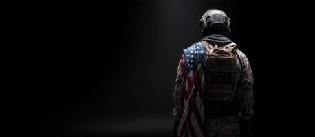 The soldier is standing in the dark with an american flag photo