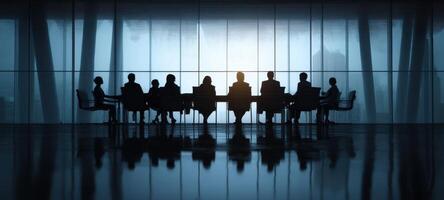 The silhouettes of business professionals engaging in a strategic meeting at sunset. photo