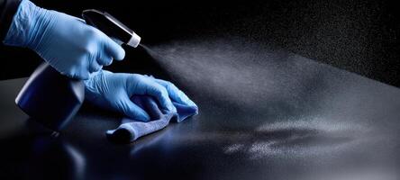 The cleaning action depicting a person using a spray bottle on a surface. photo