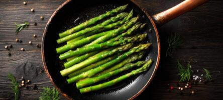 The vibrant asparagus sizzling in a frying pan ready for a gourmet meal. photo