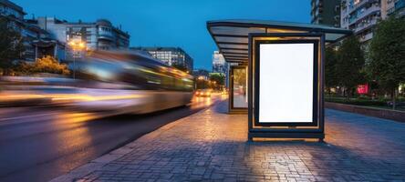 The illuminated bus stop with a blank advertising space at twilight. photo
