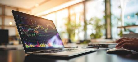 The laptop displaying vibrant financial data in a modern office setting. photo