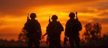 The silhouettes of soldiers standing together against a vibrant sunset backdrop. photo