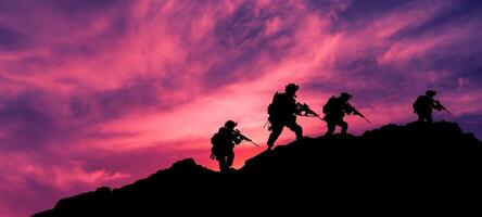 The soldiers marching across a rugged landscape during a dramatic sunset. photo