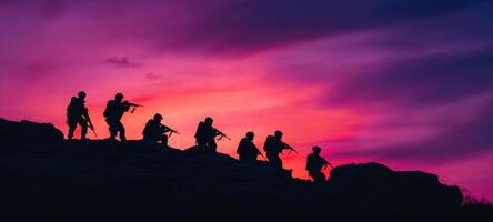 The silhouetted soldiers standing poised against a vibrant sunset sky photo