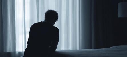 The silhouette of a man reflecting in a dimly lit hotel room photo