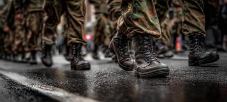 The soldiers in combat boots marching confidently down the wet street. photo