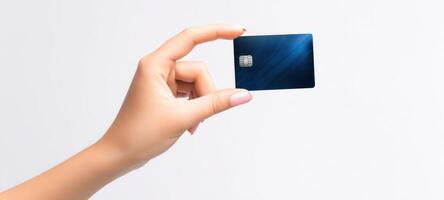 The hand holding a modern blue credit card against a light background. photo