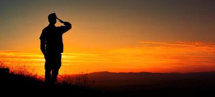 The soldier saluting against a vibrant sunset backdrop of honor and respect. photo