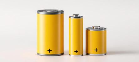 The collection of yellow batteries in various sizes on a light background. photo
