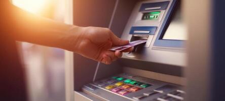 The hand inserting a card into an ATM for cash withdrawal photo