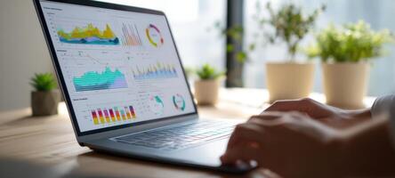 The laptop displaying colorful data analytics on a wooden workspace. photo