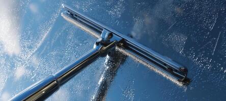 The squeegee gliding across a freshly cleaned window surface. photo