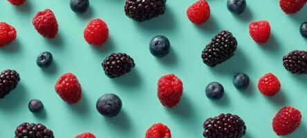 The vibrant assortment of fresh berries on a turquoise background photo