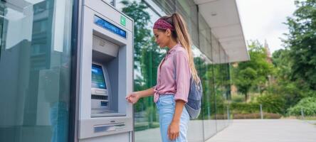 The woman using an ATM in an urban setting for financial transactions. photo