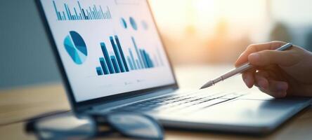 The hand analyzing data trends on a laptop screen with graphs and charts. photo