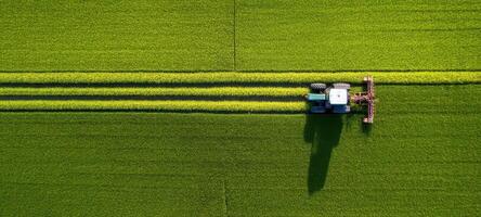 The aerial view of a tractor cultivating a vibrant green field. photo