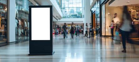 The digital display stand in a bustling modern shopping mall environment. photo