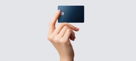 The elegant hand holding a credit card against a minimalist background. photo