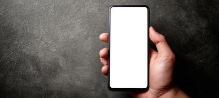 The smartphone held in a hand against a stylish gray background. photo