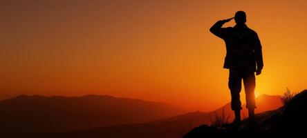The soldier salutes against a stunning sunset backdrop, symbolizing honor and bravery. photo