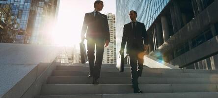 The confident businessmen walking down stairs in a vibrant urban setting. photo
