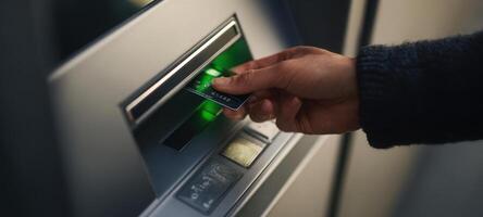 The hand using an ATM card for a banking transaction. photo