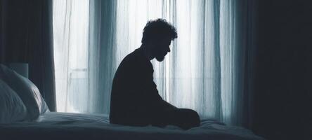 The silhouette of a man in deep contemplation at home. photo