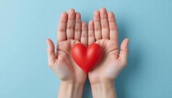Hands Holding a Red Heart Symbolizing Love and Connection Against a Soft Blue Background photo