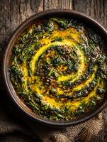 Close up of a delicious spinach dish with a creamy yellow sauce in a rustic bowl. photo