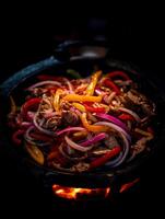 Close up of sizzling fajitas cooking in a cast iron skillet over an open flame. photo