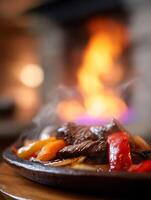 Sizzling Beef and Peppers on a Hot Plate with Flames in the Background. photo